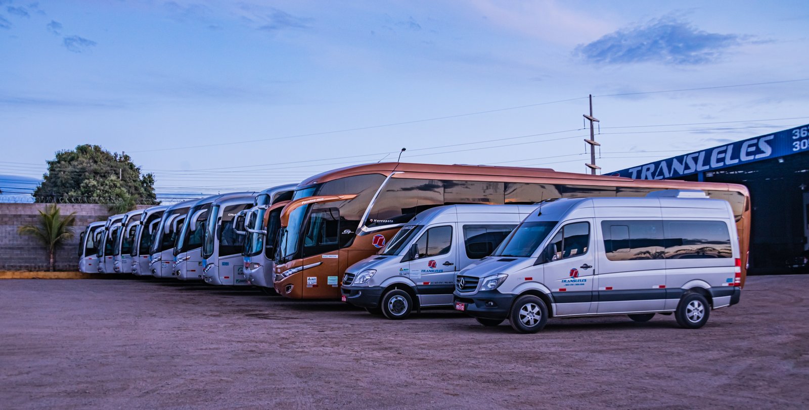 frota de vans, ônibus e micro ônibus enfilereirados na garagem